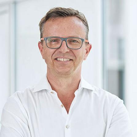 [Translate to Englisch:] Portraitfoto Prof. Robert Hube, lächelnd, Arzt der OCM Orthopädische Chirurgie München