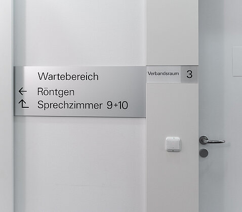Silbernes Türschild Wartebereich Röntgen der OCM Orthopädische Chirurgie München