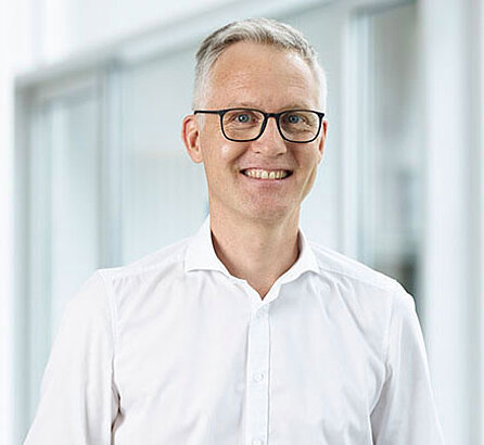 [Translate to Englisch:]   Portraitbild Dr. Markus Schrödel, lächelnd, Arzt der OCM Orthopädische Chirurgie München
