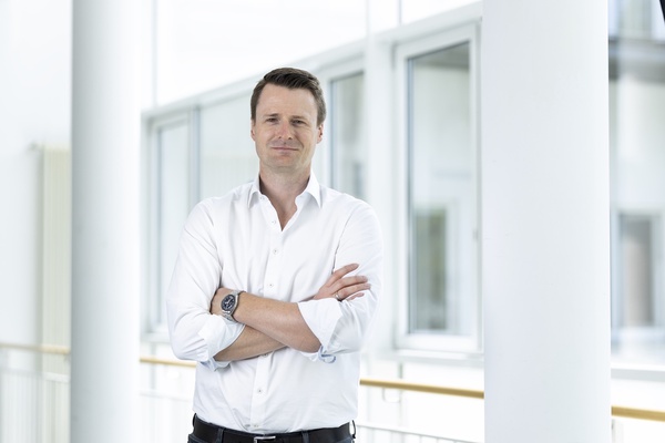 Halbportrait Prof. Dr. Patric Raiss, weißes Hemd, lächelnd