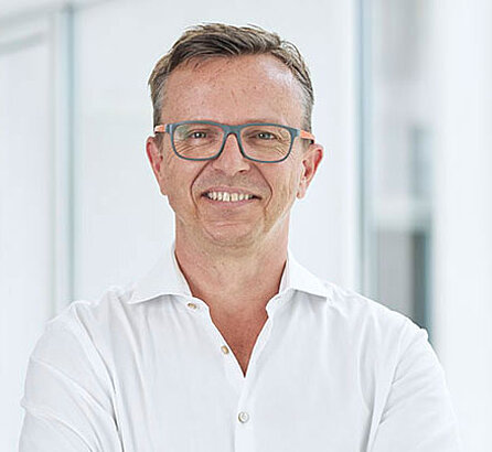 Portrait Prof. Dr. Robert Hube, Facharzt der OCM, weißes Hemd, lächelnd