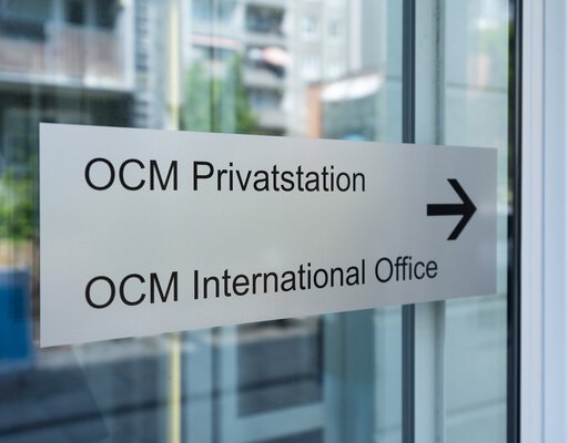 Eingangstürschild zum International Office der OCM, silberfarben mit schwarzer Schrift