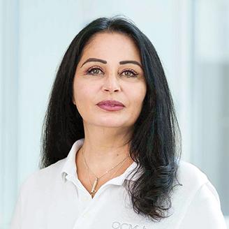 Portrait Maha Al Asta, Mitarbeiterin im International Office der OCM, weiße Bluse, freundlicher Gesichtsausdruck