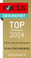 Focus Top Mediziner Siegel 2024 Schulterchirurgie Prof. Dr. Ernst Wiedemann, goldfarbenes Siegel mit weißer und schwarzer Schrift